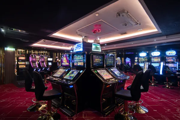 A woman in a luxurious green gown next to an ornate roulette wheel, capturing the upscale casino mood of K677.